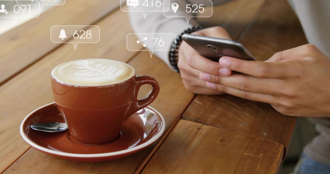 Browsing Smartphone Beside Latte Art Cup on Wooden Table with Social Media Notifications