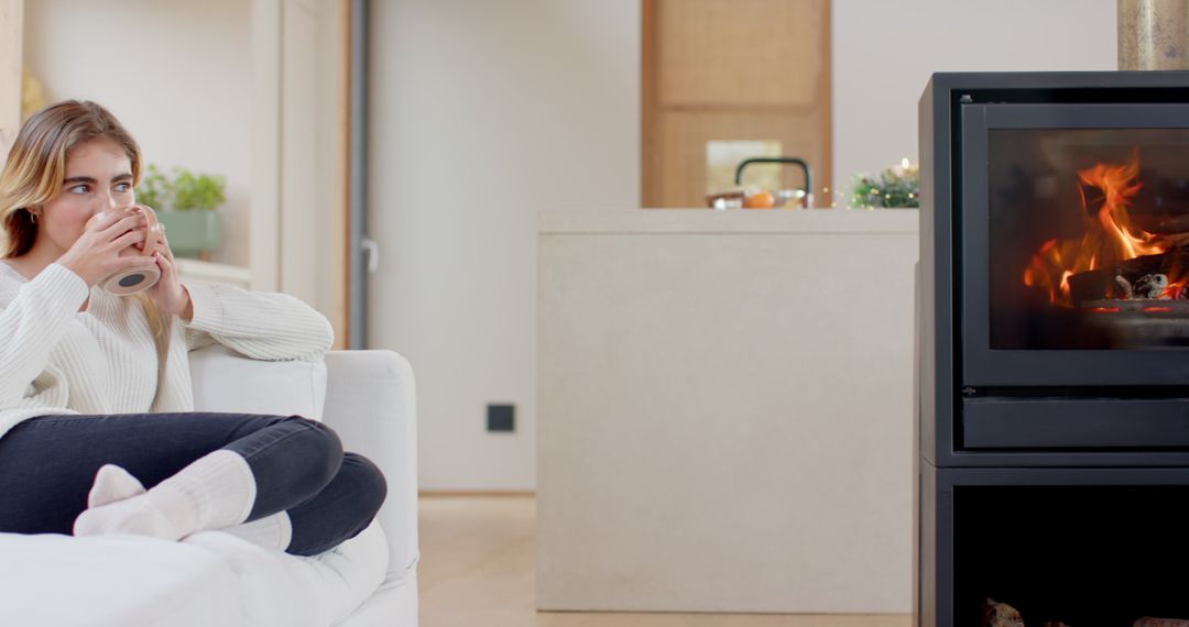 Woman Relaxing by Cozy Fireplace in Modern Living Room