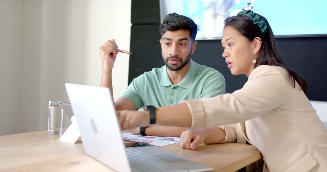 Focused Business Team Collaborating on a Project Using Laptop