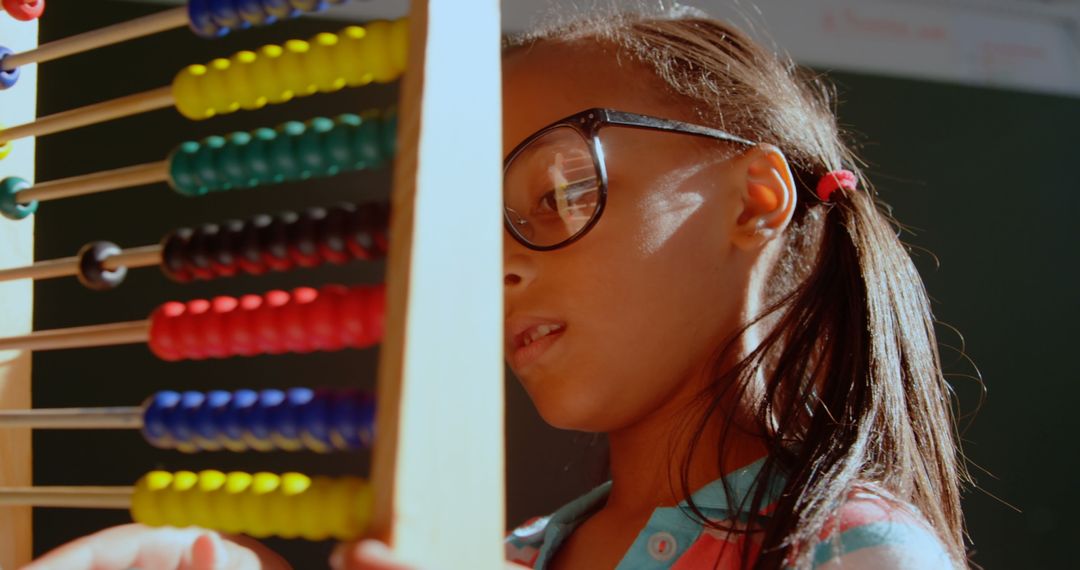 Schoolgirl Concentrating on Abacus Math Practice in Classroom Environment