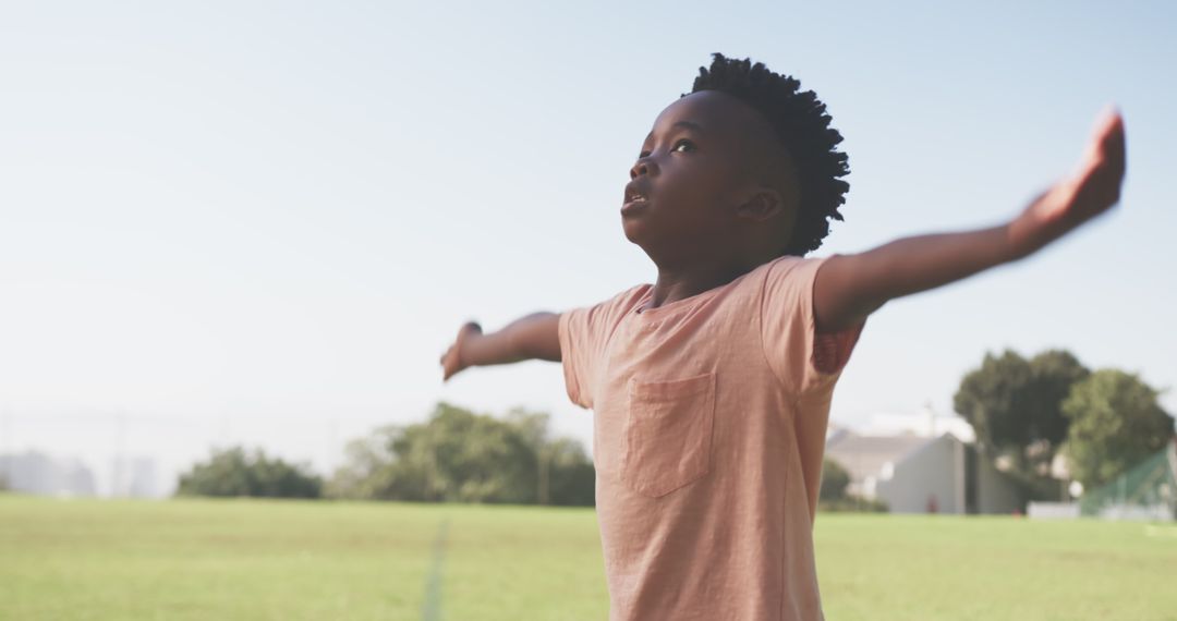 Joyful Child with Open Arms Embracing Freedom on Sunny Field