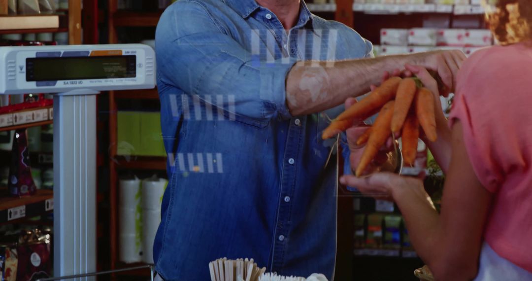 Vendor handing fresh carrots to customer at market checkout with scale and denim shirt
