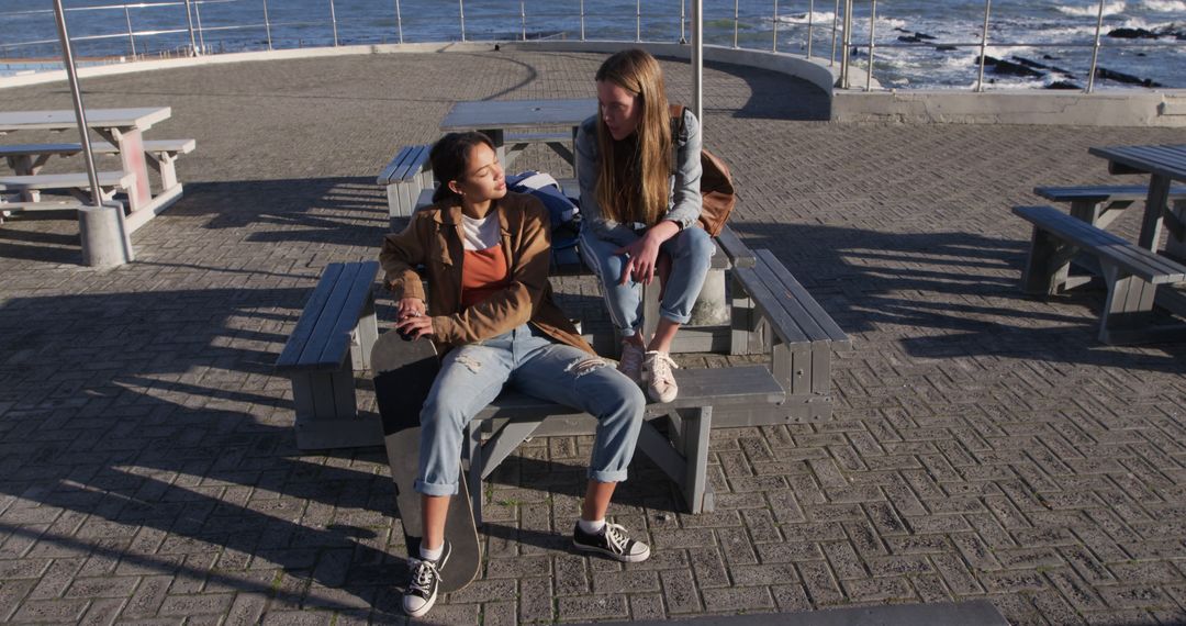 Teen Girls Having Conversation at Seaside During Sunset - Free Images, Stock Photos and Pictures on Pikwizard.com