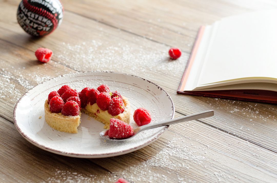 Rustic Raspberry Tart with Open Cookbook on Wooden Table
