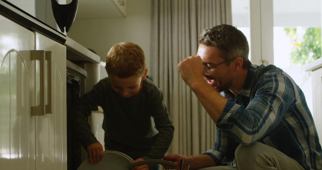 Father and Son Loading Dishwasher Together in Kitchen - Free Images, Stock Photos and Pictures on Pikwizard.com