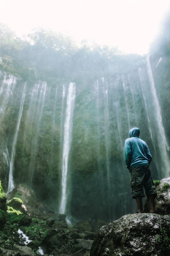 Solitary Traveler Standing by Waterfall Mist - Free Images, Stock Photos and Pictures on Pikwizard.com