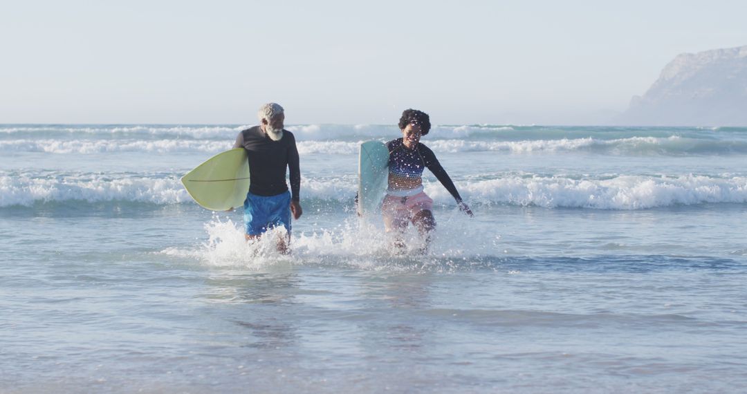 Couple Playing on the Beach with Body Boards in Sunny Weather - Free Images, Stock Photos and Pictures on Pikwizard.com