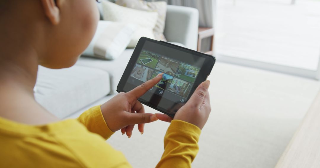 Person Using Tablet for Home Security System in Living Room - Free Images, Stock Photos and Pictures on Pikwizard.com