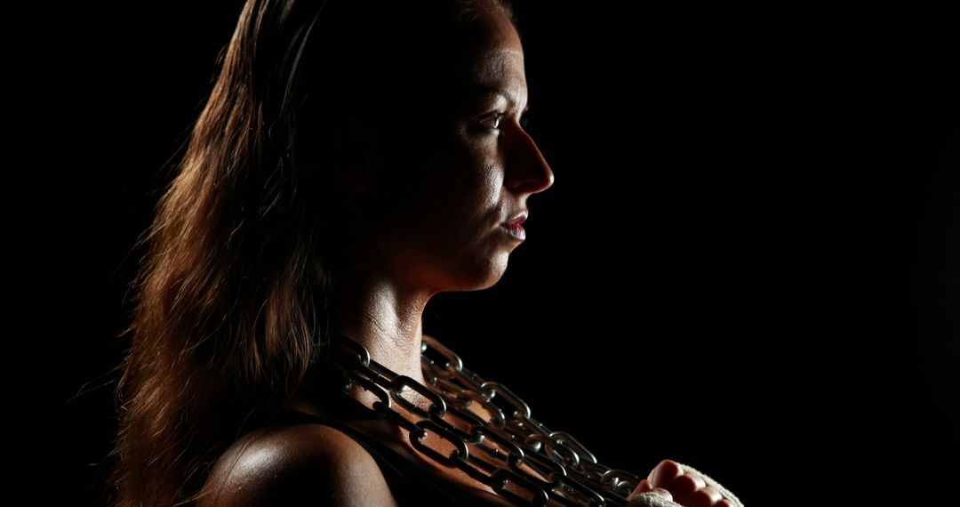 Determined Woman Holding Chains in Dramatic Lighting - Free Images, Stock Photos and Pictures on Pikwizard.com