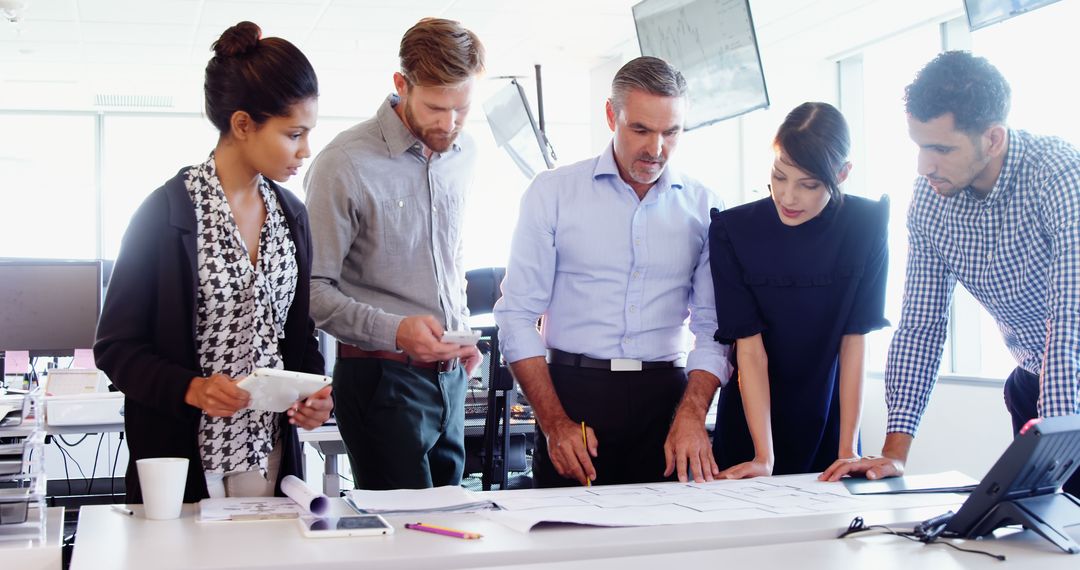 Diverse Business Team Collaborating on Project in Bright Office