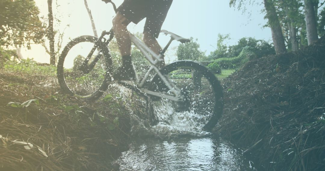 Cyclist Riding Through Water in Nature Setting