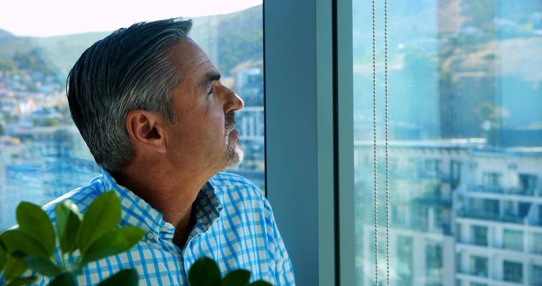 Pensive Man Looking Out Window in Modern Office - Free Images, Stock Photos and Pictures on Pikwizard.com