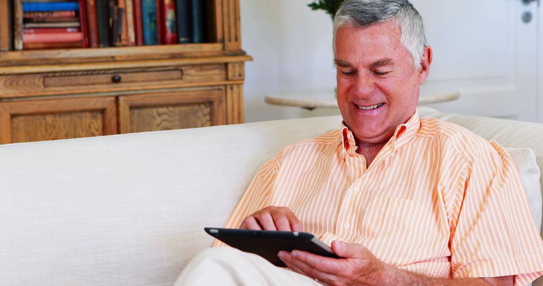 Senior Man Using Digital Tablet in Living Room - Free Images, Stock Photos and Pictures on Pikwizard.com