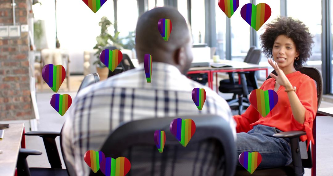 Colleagues collaborating in modern open-plan office with rainbow hearts promoting Pride teamwork