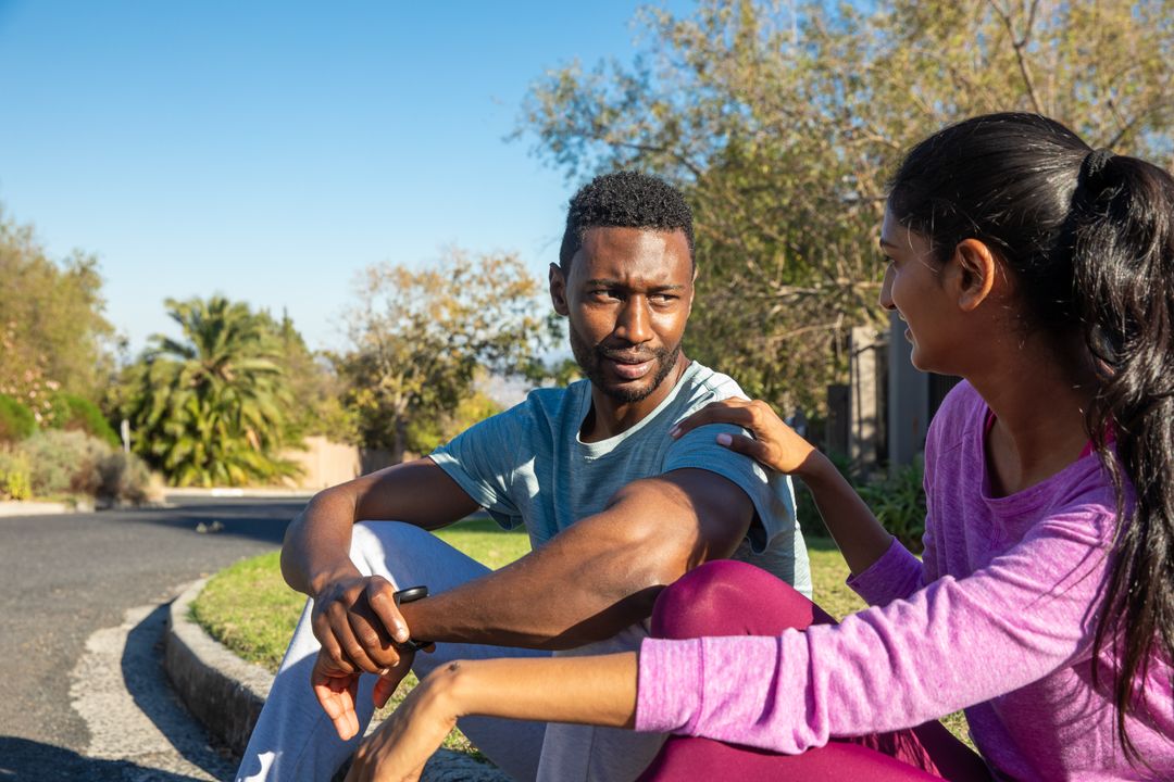 Diverse Couple Taking Rest After Outdoor Run in Suburban Area