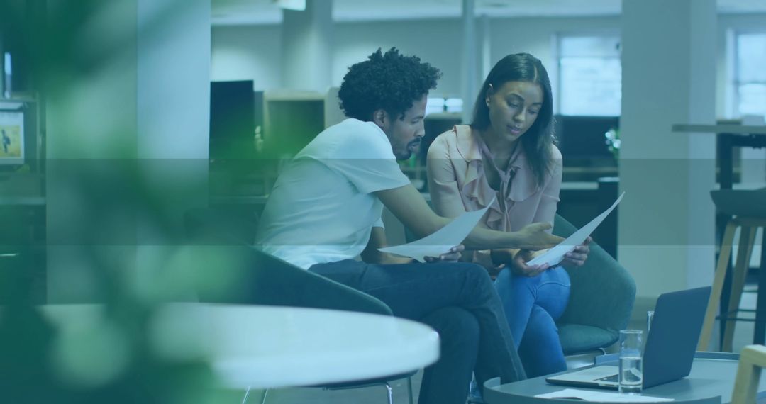 Office Colleagues Collaborating on Documents in Modern Workspace