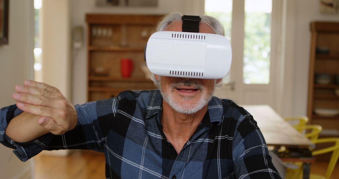 Senior Man Experiencing Virtual Reality with VR Headset in Modern Home - Free Images, Stock Photos and Pictures on Pikwizard.com