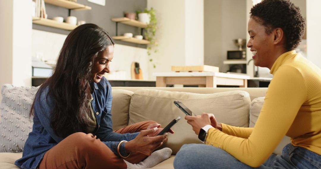 Diverse Women Relaxing on Sofa Using Smartphones at Home