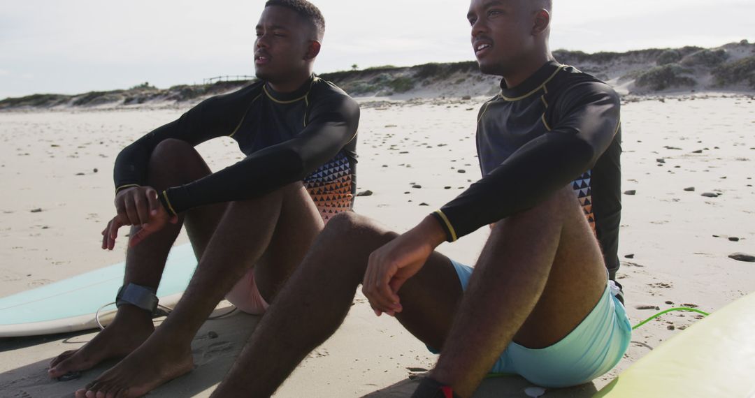 Two Young Men Sitting on Beach with Surfboards Relaxing and Talking - Free Images, Stock Photos and Pictures on Pikwizard.com