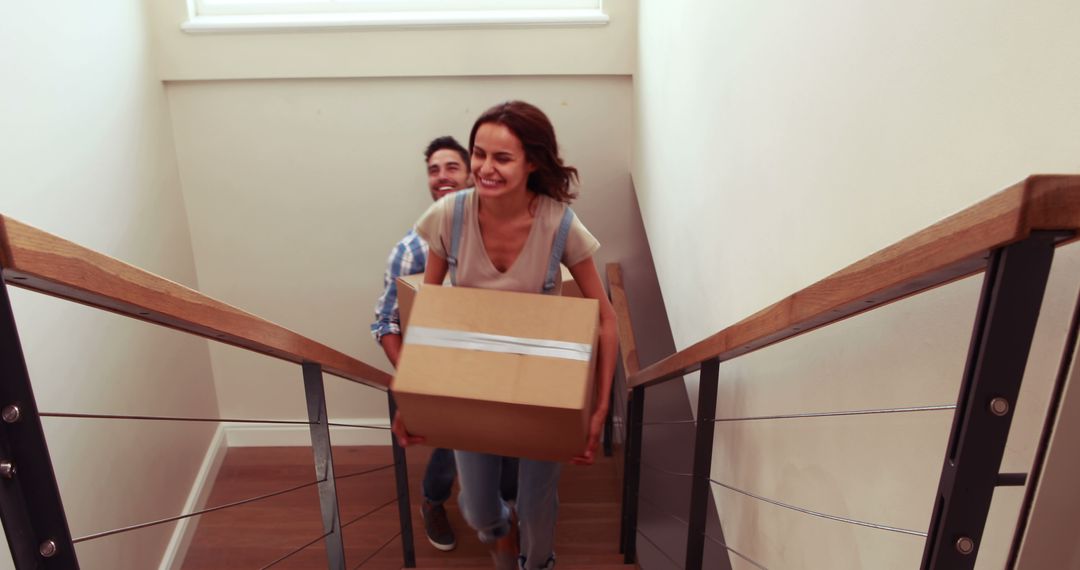 Young Couple Moving into New Home Carrying Boxes Up Stairs - Free Images, Stock Photos and Pictures on Pikwizard.com