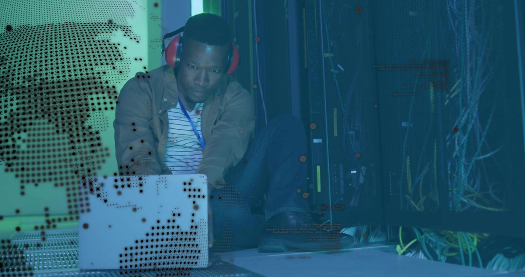 Technician Working on Laptop in Data Center with Red Headphones