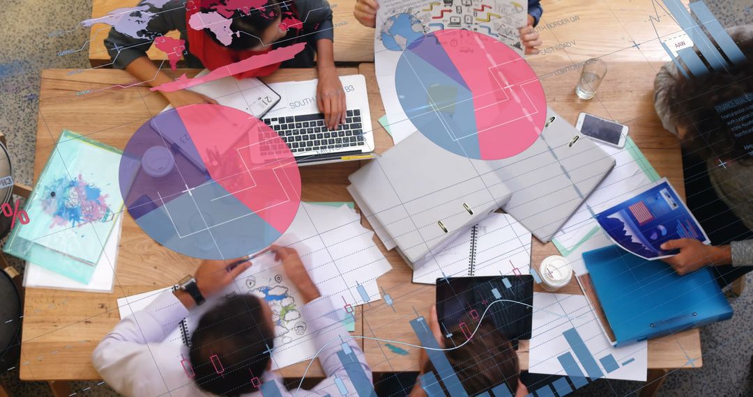 Team Working on Project with Laptops and Graphs at Office Desk