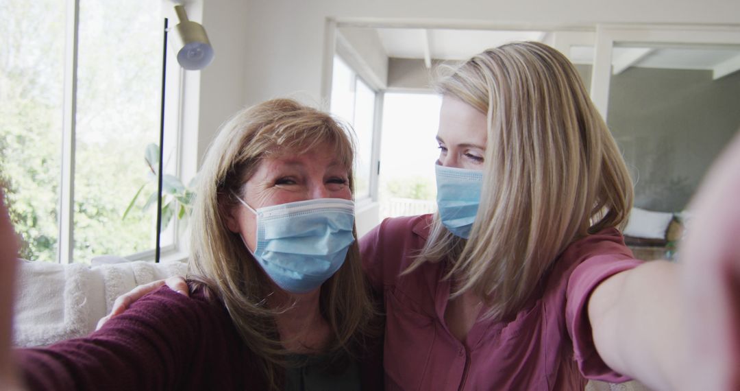 Two Women Taking a Selfie at Home Wearing Medical Masks - Free Images, Stock Photos and Pictures on Pikwizard.com