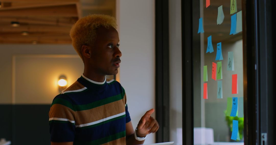 Young Professional Strategizing with Sticky Notes and Tablet