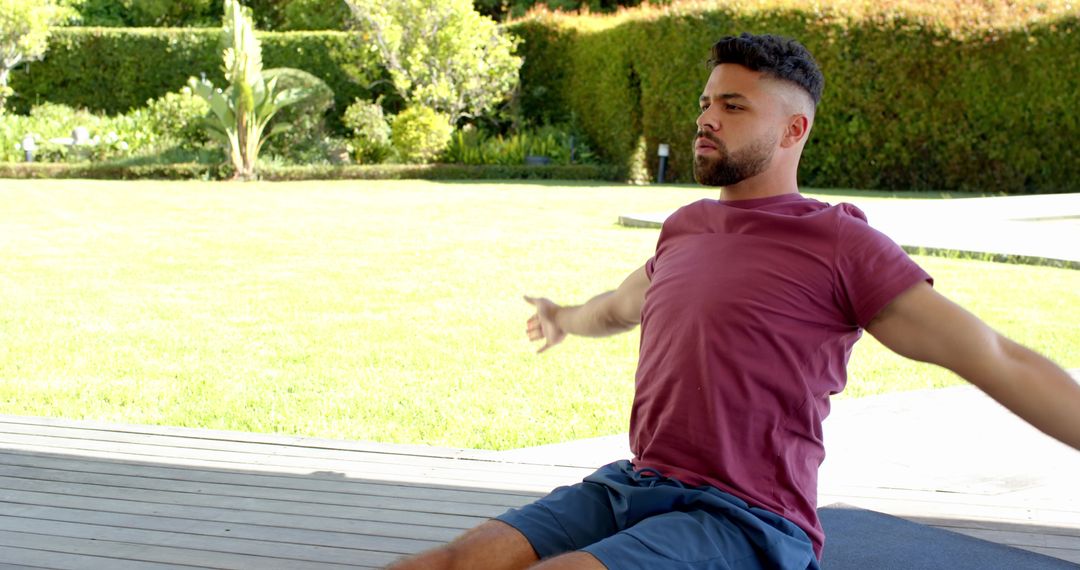 Man Practicing Outdoor Meditation and Stretching on Wooden Deck