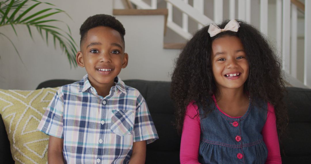 Smiling African American Siblings Sitting on Couch at Home - Free Images, Stock Photos and Pictures on Pikwizard.com