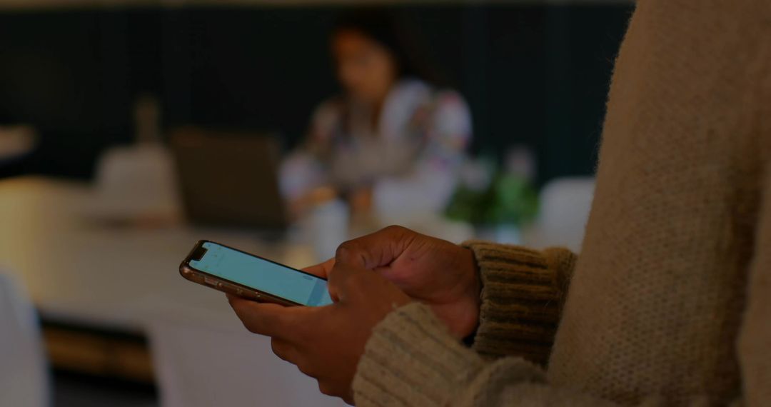 Professional Using Smartphone in Modern Workspace