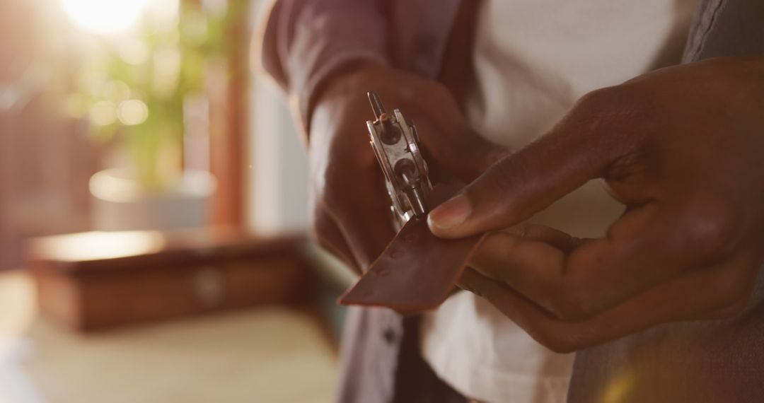 African American Craftsman Punching Leather in Workshop