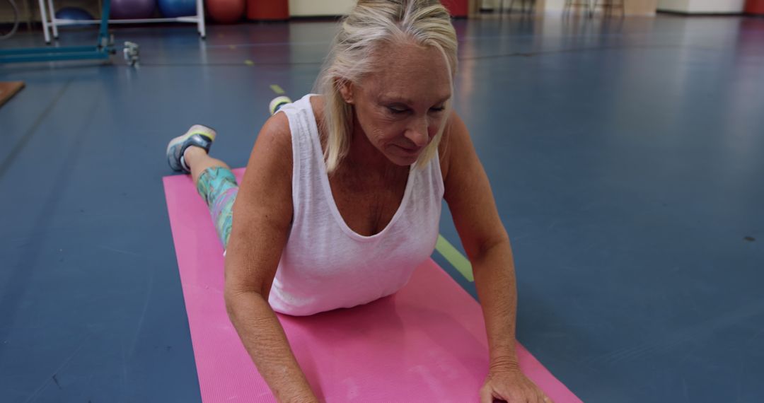 Senior Woman Practicing Yoga on Pink Mat in Gym - Free Images, Stock Photos and Pictures on Pikwizard.com