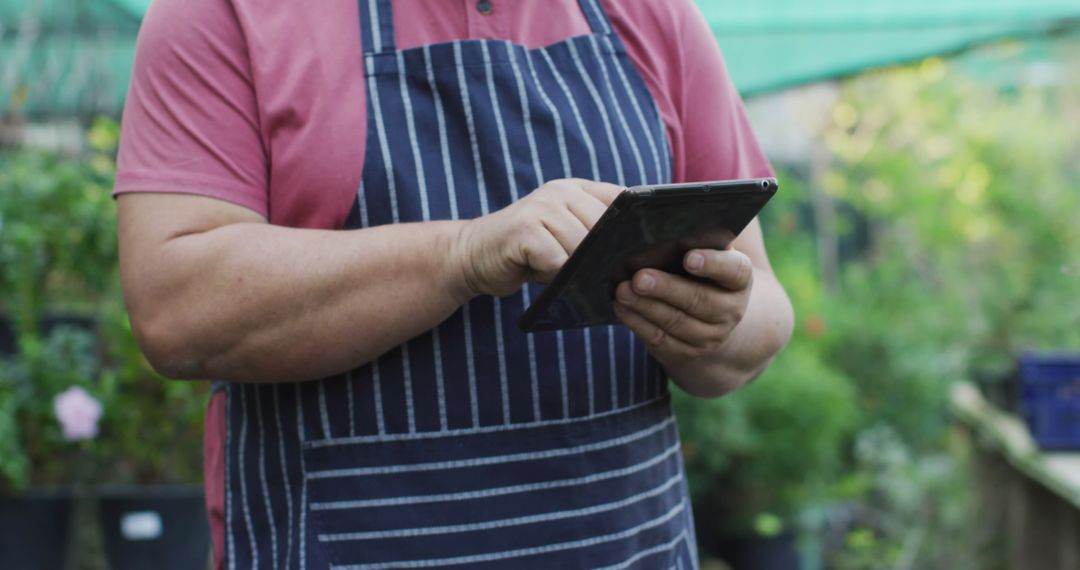 Gardener Using Digital Tablet in Vibrant Nursery