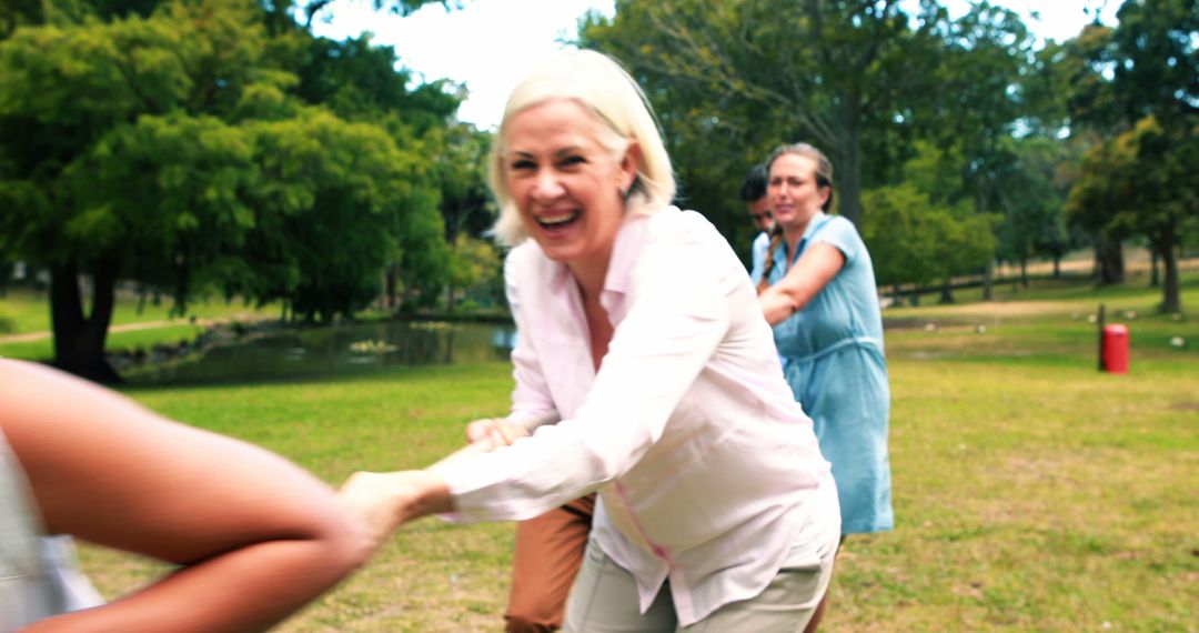 Group of Women Smiling and Playing Tug of War in Park - Free Images, Stock Photos and Pictures on Pikwizard.com