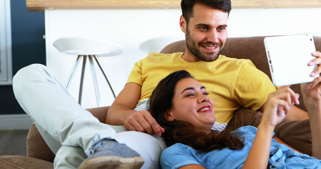Cheerful Couple Relaxing and Using Digital Tablet Together
