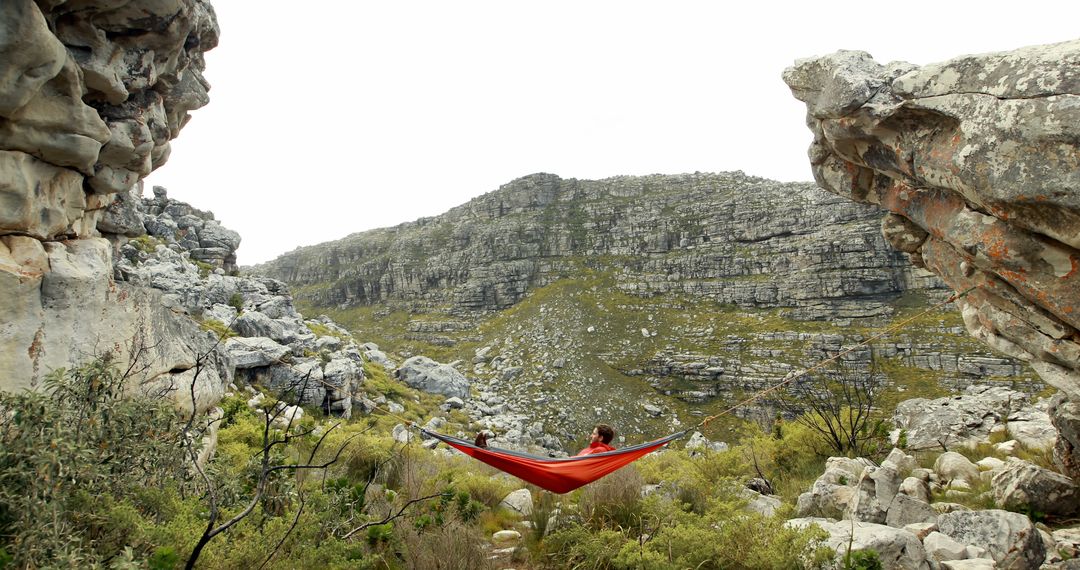 Person Relaxing in Hammock Amid Cliff Rocks in Remote Mountain Landscape - Free Images, Stock Photos and Pictures on Pikwizard.com