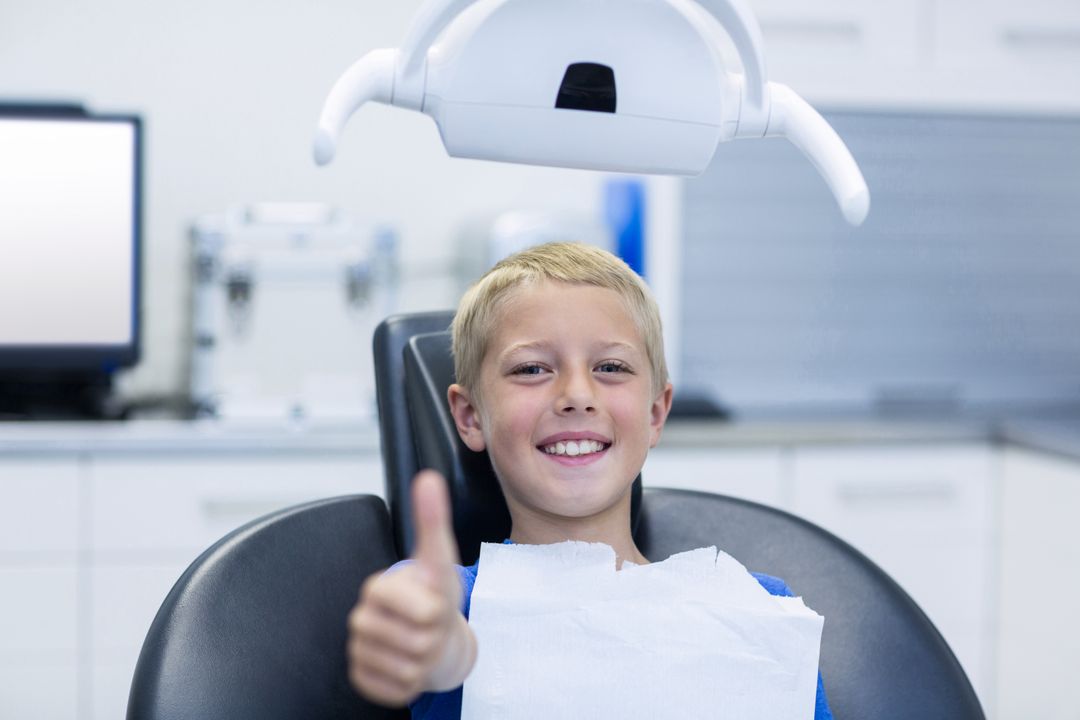 Smiling young patient sitting on dentist chair - Free Images, Stock Photos and Pictures on Pikwizard.com
