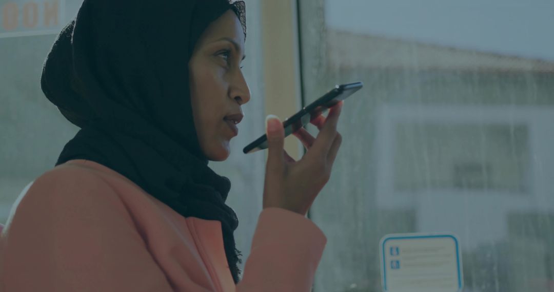 Woman in Headscarf Speaking on Smartphone during Bus Commute