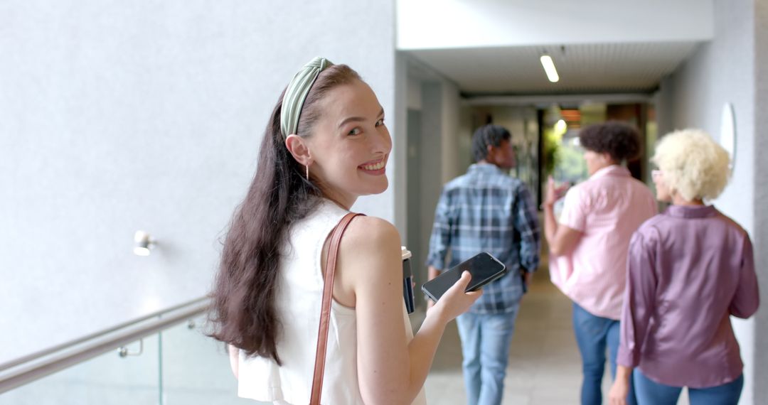 Smiling Woman Walking in Hallway with Technology