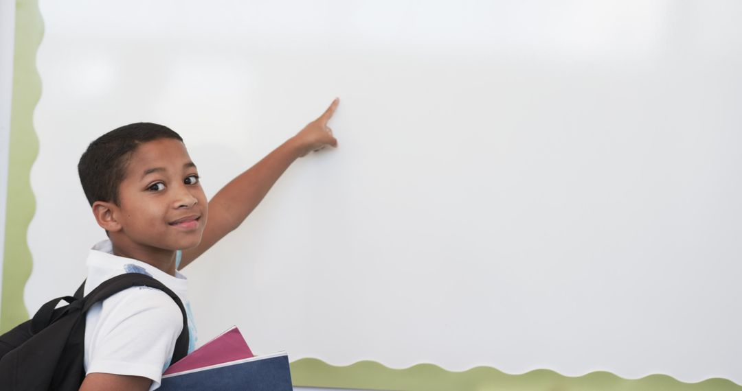 Young Student Pointing at Blank Whiteboard