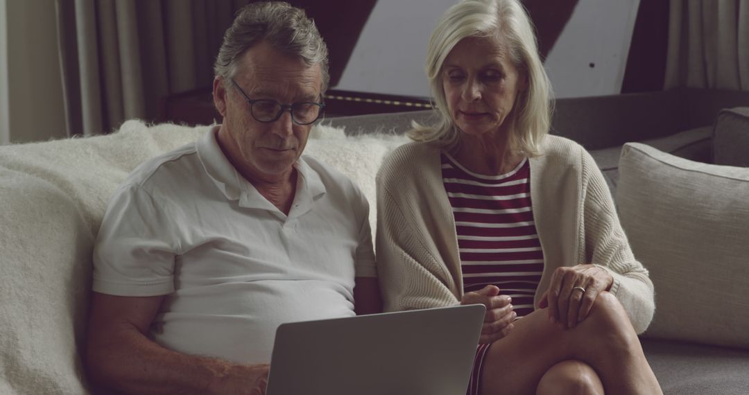 Senior Couple Engaged in Online Browsing Together at Home