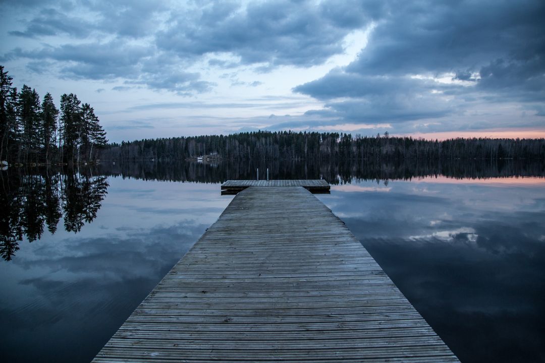 Wooden Dock Extending into Tranquil Lake at Dusk - Free Images, Stock Photos and Pictures on Pikwizard.com