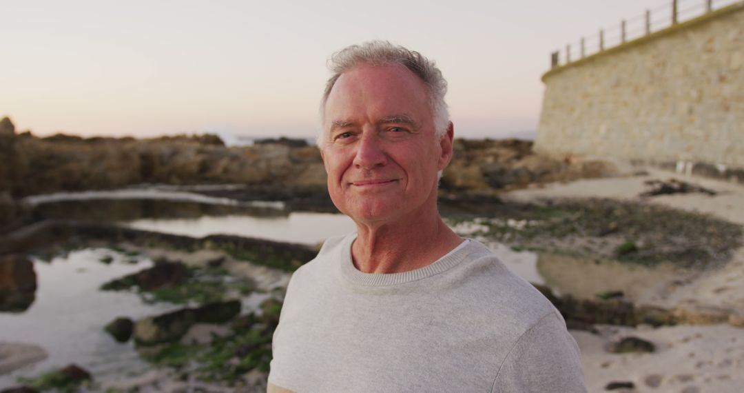 Smiling Senior Man Enjoying Beachside at Sunset - Free Images, Stock Photos and Pictures on Pikwizard.com