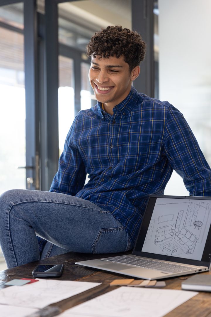 Young Designer Reviewing Sketches in Modern Studio