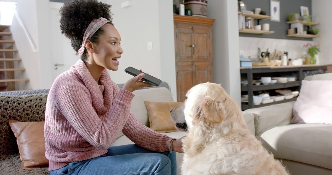 Woman Interacting with Smart Home Device While Petting Dog - Free Images, Stock Photos and Pictures on Pikwizard.com