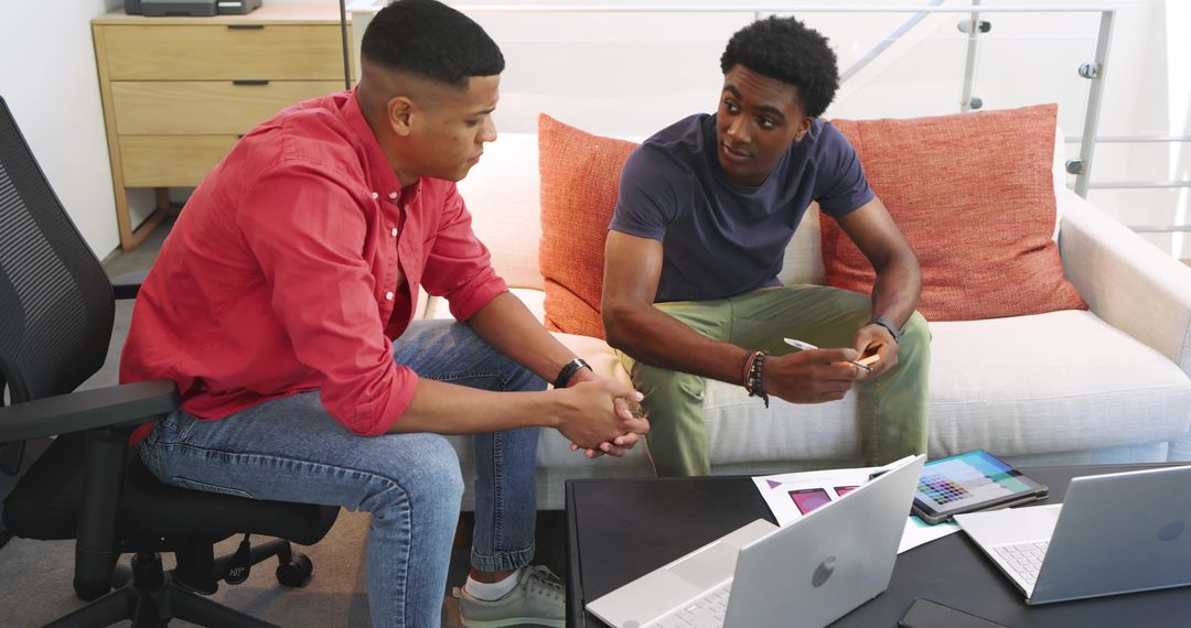 Creative Coworkers Discussing Design Mockups in Modern Office Lounge