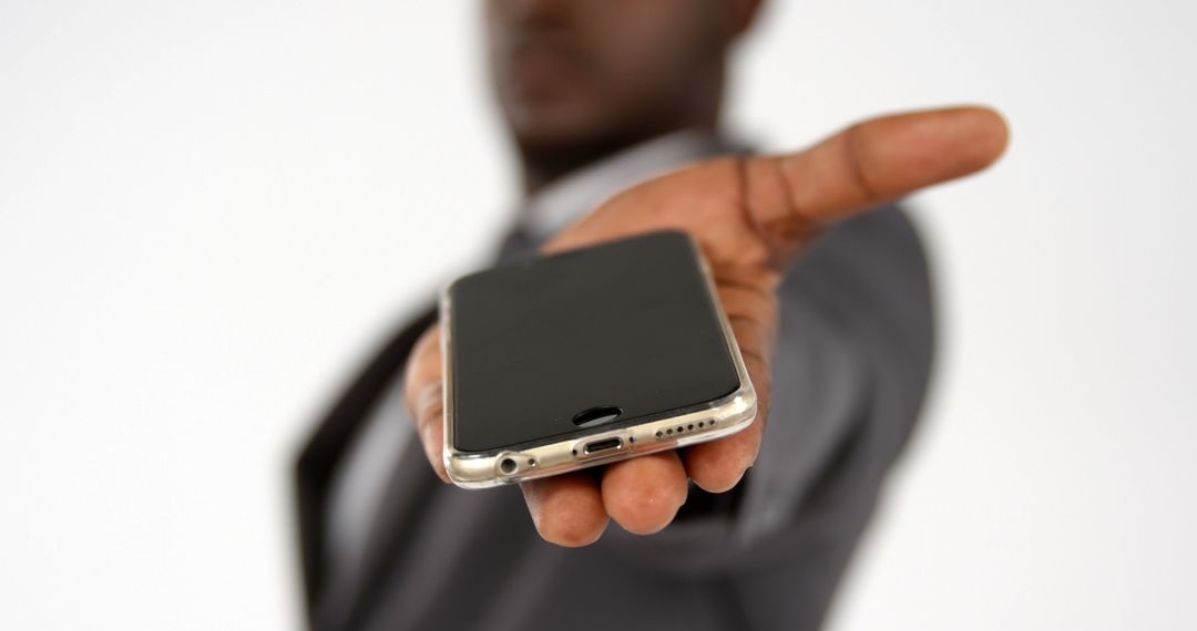 Businessman Presenting Smartphone in Hand - Free Images, Stock Photos and Pictures on Pikwizard.com