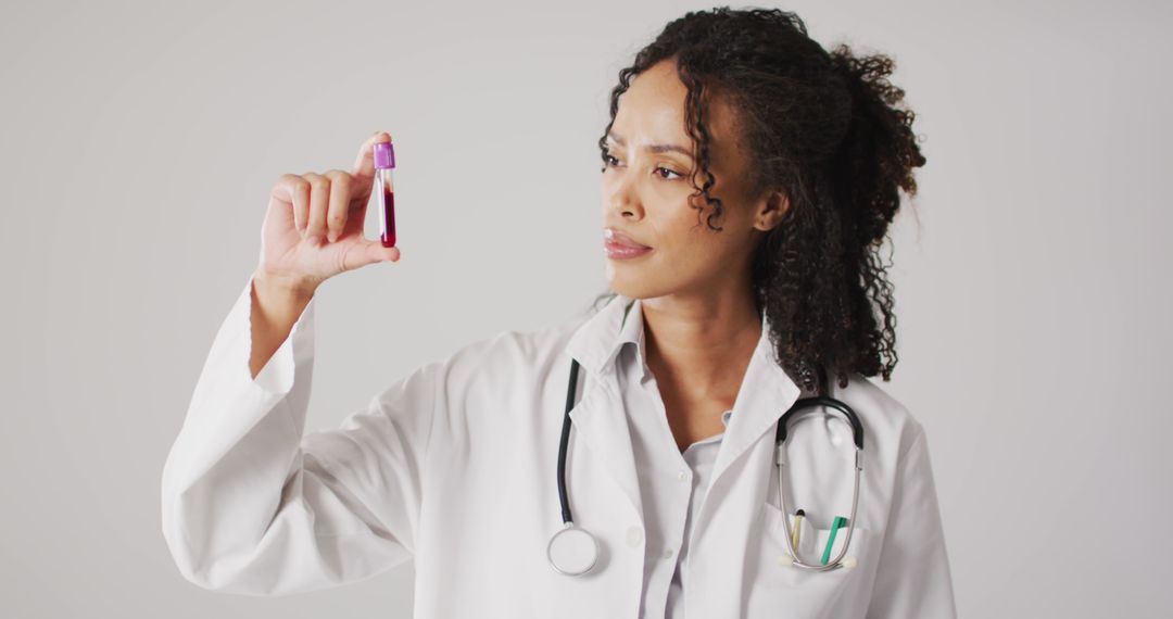 Image of biracial female doctor holding test tube on white background - Free Images, Stock Photos and Pictures on Pikwizard.com