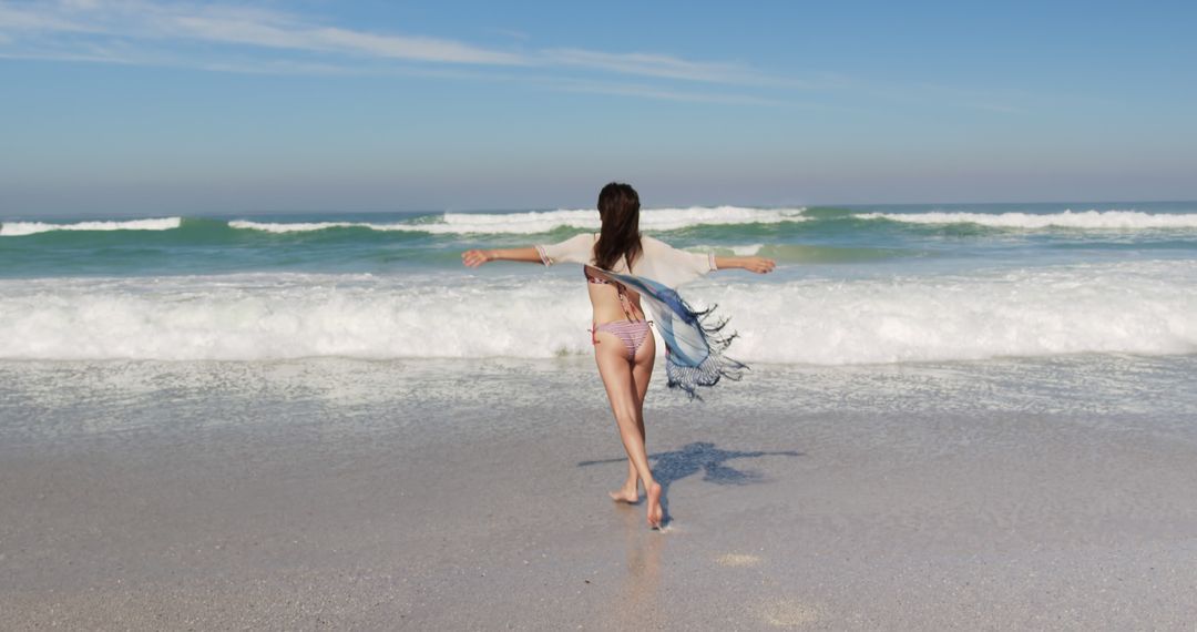 Woman Enjoying Walk on Sandy Beach With Waves in Background, Blue Sky - Free Images, Stock Photos and Pictures on Pikwizard.com